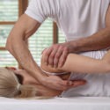 chiropractor adjusting a woman’s shoulder