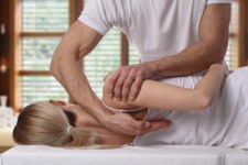 chiropractor adjusting a woman’s shoulder