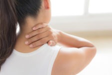 woman holding her neck in pain