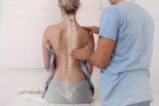 chiropractor helping a female patient with a vector of her spine